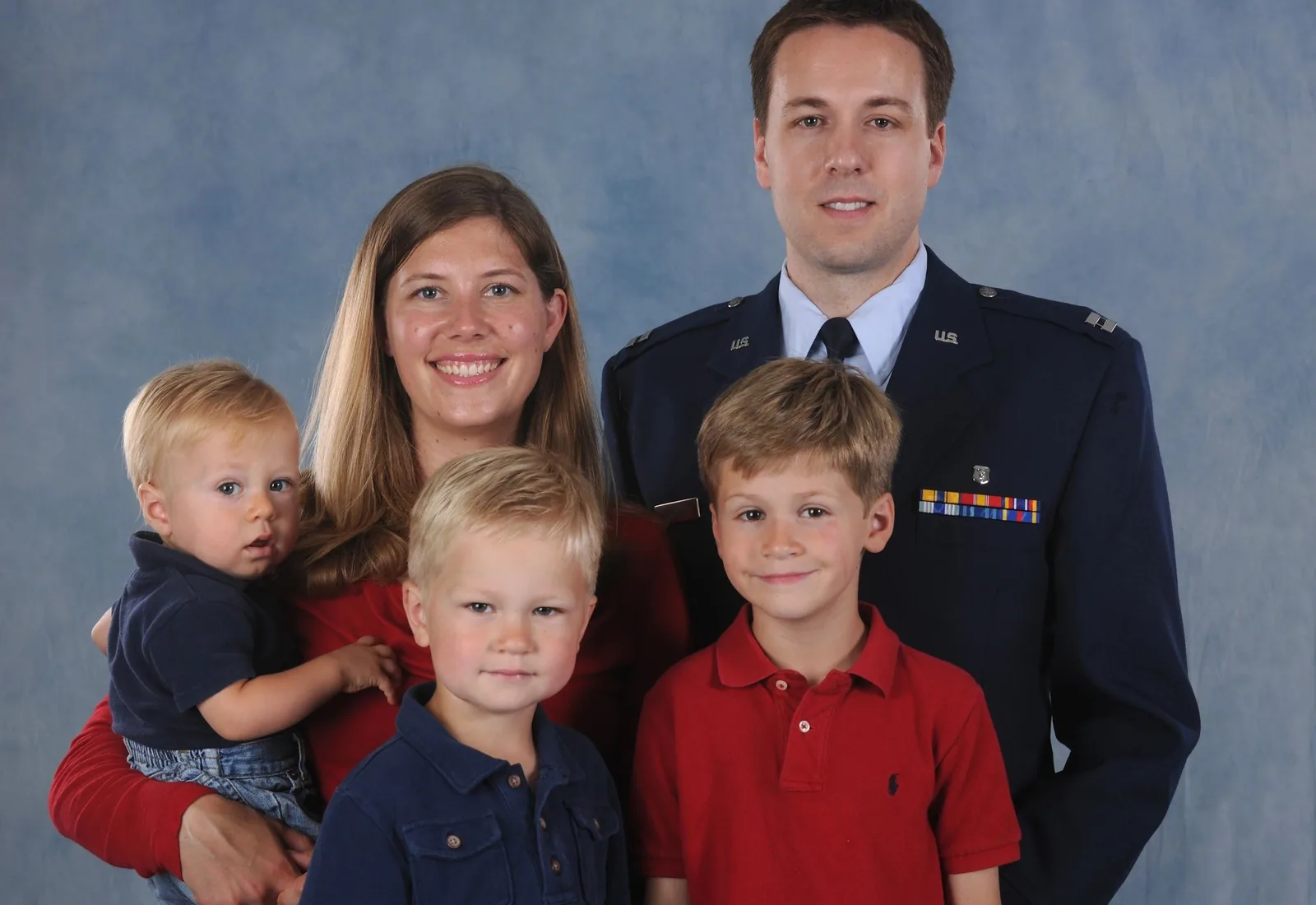 Family portrait with two adults and three children, including one adult wearing a military uniform.