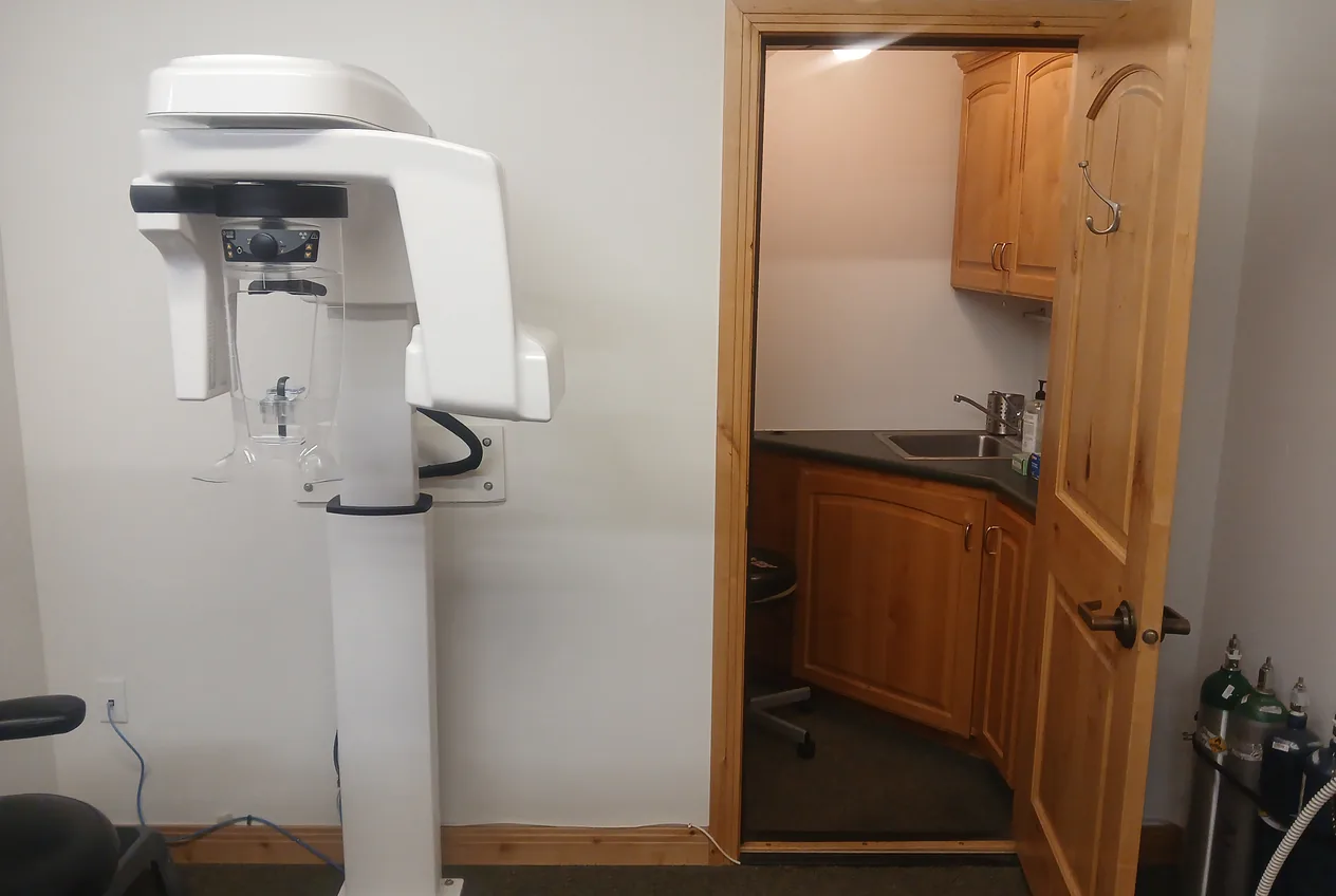The panoramic X-ray machine beside the door to the sterilization room.